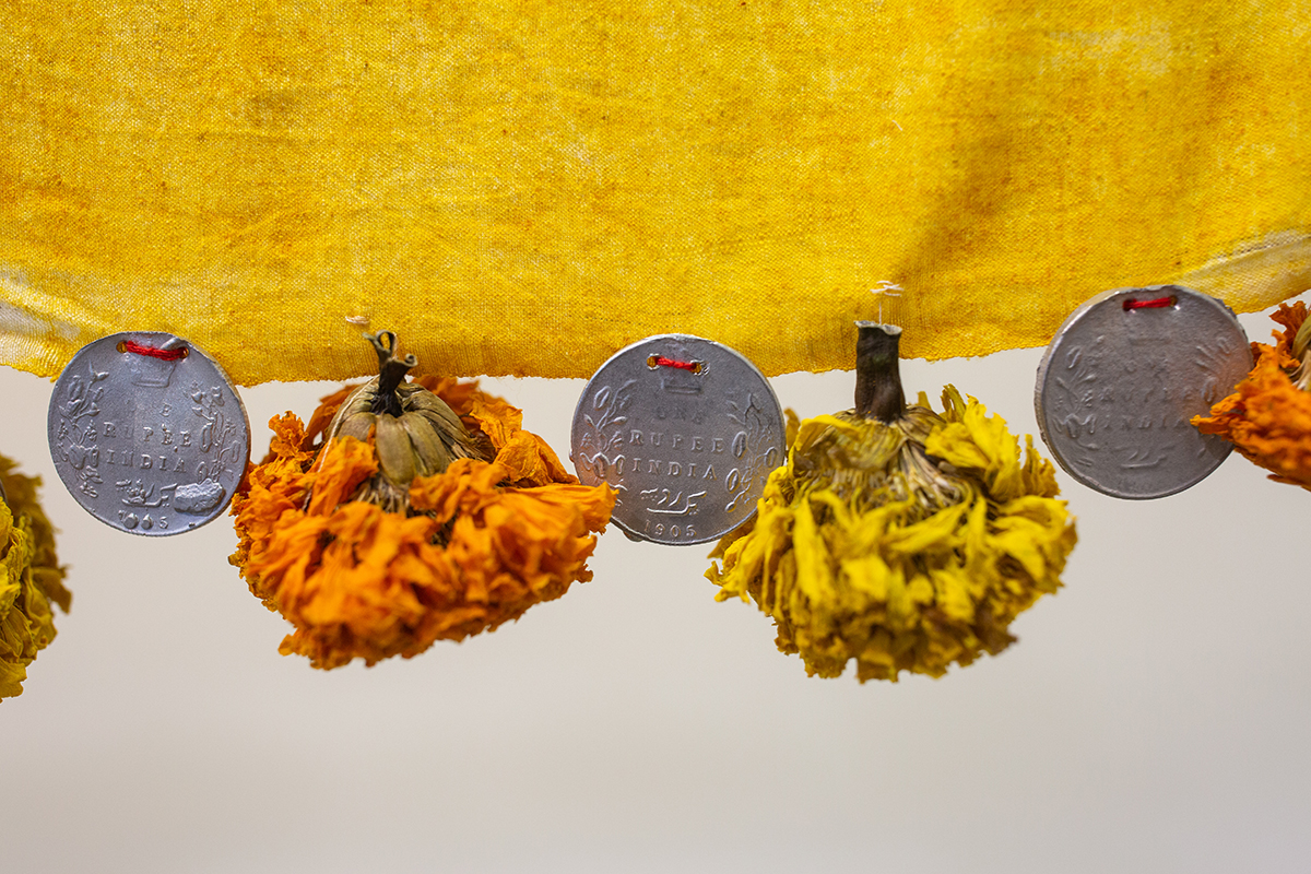 Installation of embroidered fabrics hanging from sugarcane, suspended from ceiling